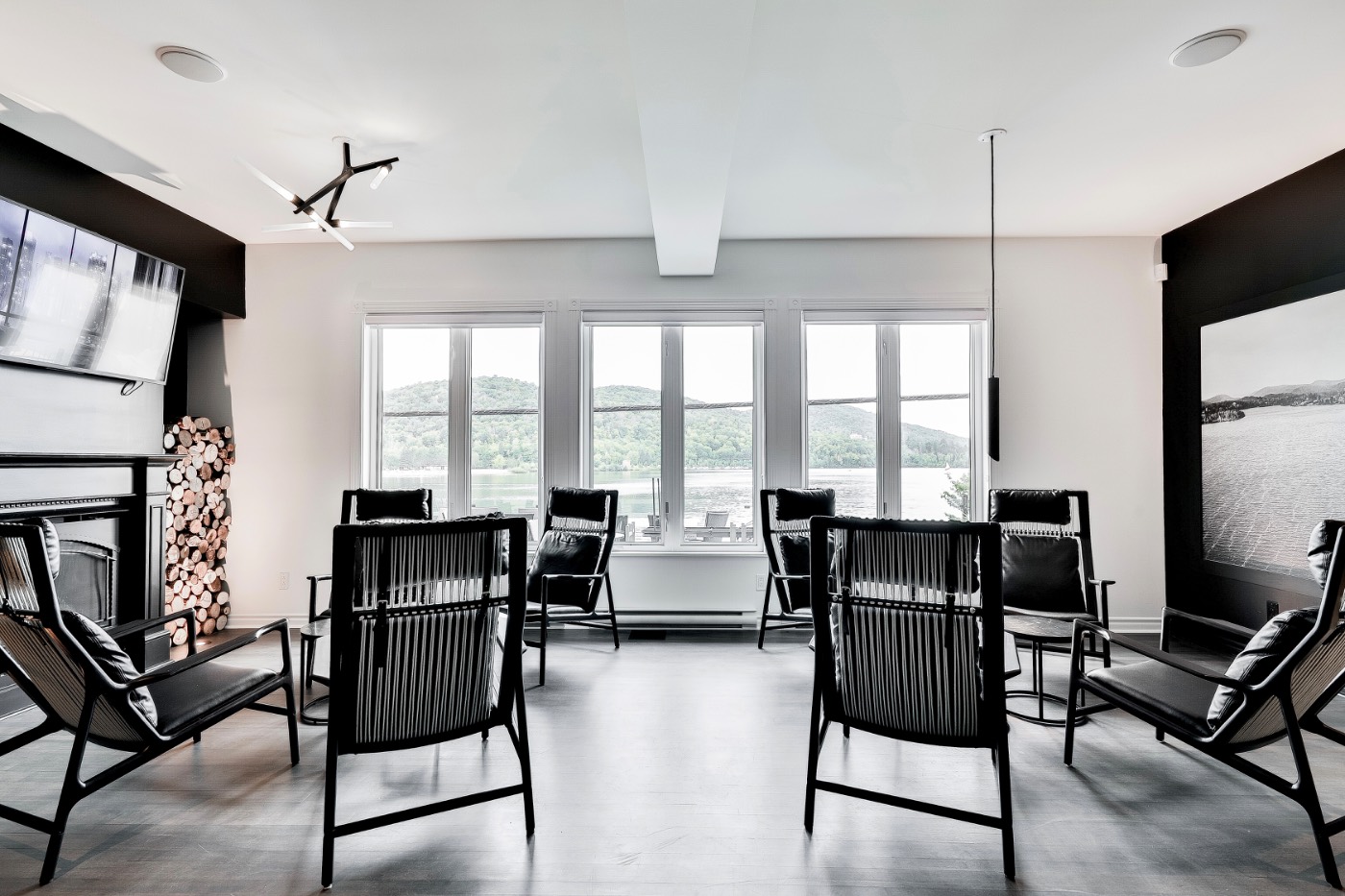 Salon avec fauteuils et grandes fenêtres donnant sur le lac