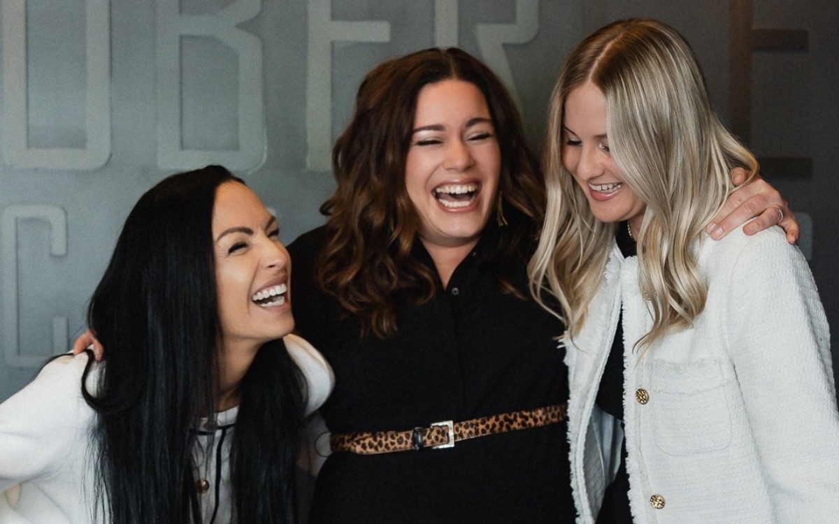 Three friends laughing together at the Auberge
